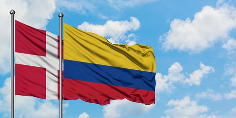Denmark and Colombia flag waving in the wind against white cloudy blue sky together. Diplomacy concept, international relations.