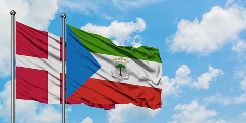 Denmark and Equatorial Guinea flag waving in the wind against white cloudy blue sky together. Diplomacy concept, international relations.