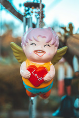 Cupid clay doll hanging in the tree of garden.