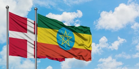 Denmark and Ethiopia flag waving in the wind against white cloudy blue sky together. Diplomacy concept, international relations.