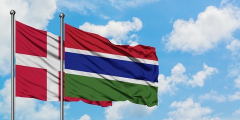 Denmark and Gambia flag waving in the wind against white cloudy blue sky together. Diplomacy concept, international relations.