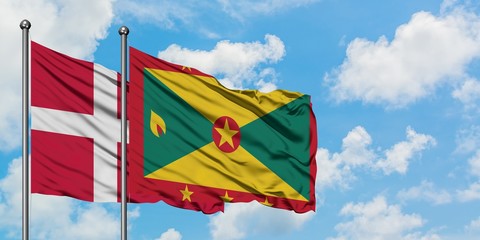 Denmark and Grenada flag waving in the wind against white cloudy blue sky together. Diplomacy concept, international relations.