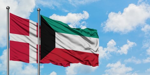 Denmark and Kuwait flag waving in the wind against white cloudy blue sky together. Diplomacy concept, international relations.
