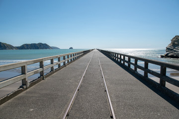 Railway track down the middle of the very long historic wharf at Tolaga Bay