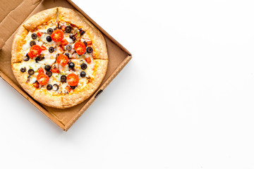 Pizza delivery. Italian food in box on white background top view copy space