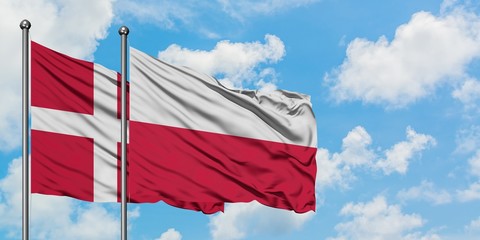 Denmark and Poland flag waving in the wind against white cloudy blue sky together. Diplomacy concept, international relations.