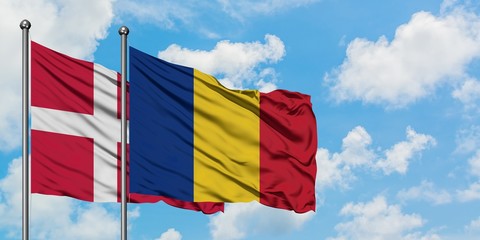 Denmark and Romania flag waving in the wind against white cloudy blue sky together. Diplomacy concept, international relations.