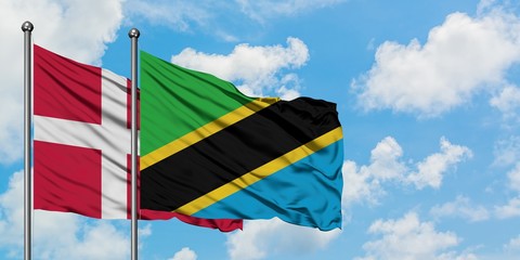 Denmark and Tanzania flag waving in the wind against white cloudy blue sky together. Diplomacy concept, international relations.