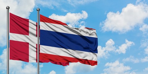 Denmark and Thailand flag waving in the wind against white cloudy blue sky together. Diplomacy concept, international relations.