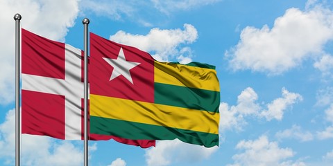 Denmark and Togo flag waving in the wind against white cloudy blue sky together. Diplomacy concept, international relations.