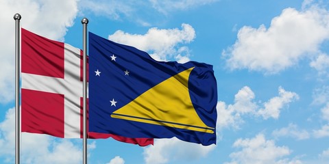 Denmark and Tokelau flag waving in the wind against white cloudy blue sky together. Diplomacy concept, international relations.