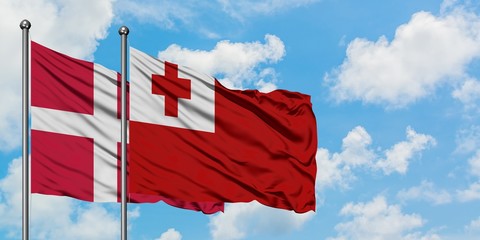 Denmark and Tonga flag waving in the wind against white cloudy blue sky together. Diplomacy concept, international relations.