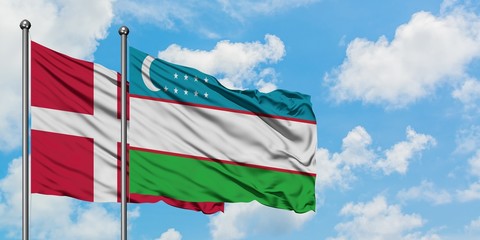 Denmark and Uzbekistan flag waving in the wind against white cloudy blue sky together. Diplomacy concept, international relations.