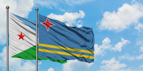 Djibouti and Aruba flag waving in the wind against white cloudy blue sky together. Diplomacy concept, international relations.