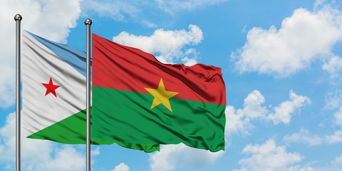 Djibouti and Burkina Faso flag waving in the wind against white cloudy blue sky together. Diplomacy concept, international relations.