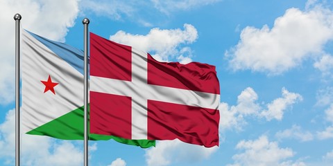 Djibouti and Denmark flag waving in the wind against white cloudy blue sky together. Diplomacy concept, international relations.