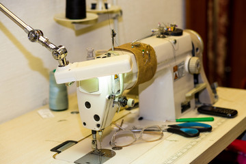 Sewing Process, Antique Sewing Machine with sewer, Lowkey lighting, factory shop. Closes making atelier with several sewing machines. Tailoring industry, fashion designer workshop, industry concept