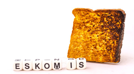 The name Eskom and a slice of burnt toast isolated on a white background image with copy space in...