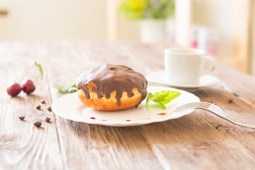 Chocolate donut with coffee on wooden table