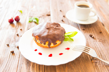 Chocolate donut or bun with an espresso on table