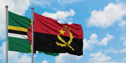 Dominica and Angola flag waving in the wind against white cloudy blue sky together. Diplomacy concept, international relations.