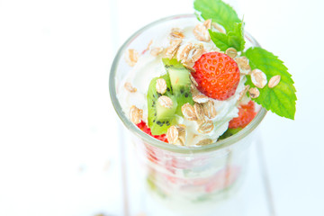 Dessert yogurt and strawberry in glass on white wooden background