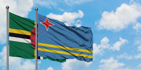 Dominica and Aruba flag waving in the wind against white cloudy blue sky together. Diplomacy concept, international relations.