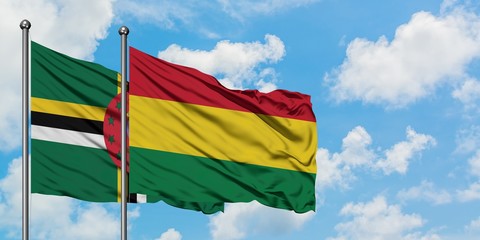 Dominica and Bolivia flag waving in the wind against white cloudy blue sky together. Diplomacy concept, international relations.