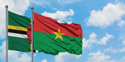 Dominica and Burkina Faso flag waving in the wind against white cloudy blue sky together. Diplomacy concept, international relations.