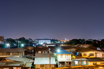 Beautiful rooftop view of cityscape of old time houses in crowded community and buildings with clear night sky in Bangkok. Dark, quiet an calm urban area.