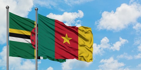 Dominica and Cameroon flag waving in the wind against white cloudy blue sky together. Diplomacy concept, international relations.