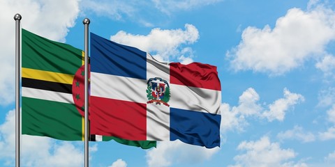 Dominica and Dominican Republic flag waving in the wind against white cloudy blue sky together. Diplomacy concept, international relations.