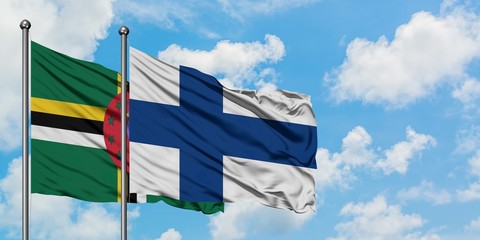Dominica and Finland flag waving in the wind against white cloudy blue sky together. Diplomacy...