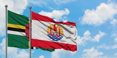 Dominica and French Polynesia flag waving in the wind against white cloudy blue sky together. Diplomacy concept, international relations.