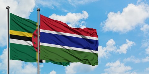 Dominica and Gambia flag waving in the wind against white cloudy blue sky together. Diplomacy concept, international relations.