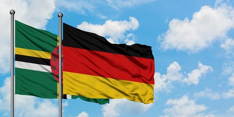 Dominica and Germany flag waving in the wind against white cloudy blue sky together. Diplomacy concept, international relations.