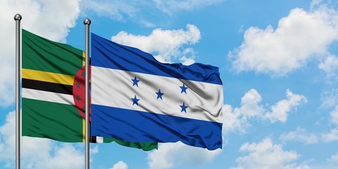 Dominica and Honduras flag waving in the wind against white cloudy blue sky together. Diplomacy concept, international relations.
