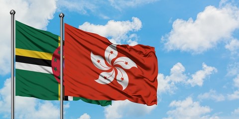 Dominica and Hong Kong flag waving in the wind against white cloudy blue sky together. Diplomacy concept, international relations.