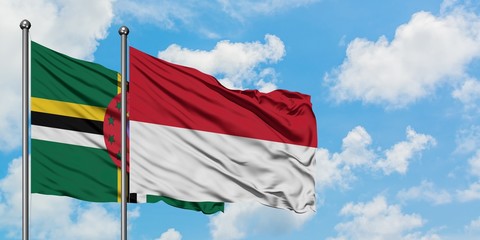 Dominica and Indonesia flag waving in the wind against white cloudy blue sky together. Diplomacy concept, international relations.