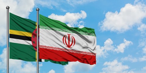 Dominica and Iran flag waving in the wind against white cloudy blue sky together. Diplomacy concept, international relations.