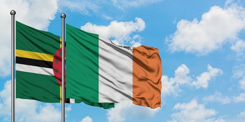 Dominica and Ireland flag waving in the wind against white cloudy blue sky together. Diplomacy concept, international relations.