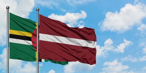 Dominica and Latvia flag waving in the wind against white cloudy blue sky together. Diplomacy concept, international relations.