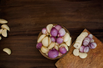 Organic fresh red onions and garlic cut into pieces with an elegant black wood background