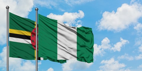 Dominica and Nigeria flag waving in the wind against white cloudy blue sky together. Diplomacy concept, international relations.