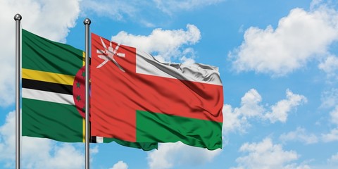 Dominica and Oman flag waving in the wind against white cloudy blue sky together. Diplomacy concept, international relations.