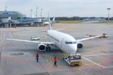 Airplane execute push back operation at airport.