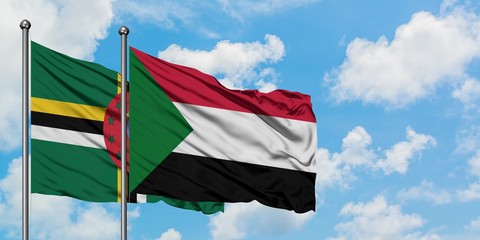 Dominica and Sudan flag waving in the wind against white cloudy blue sky together. Diplomacy concept, international relations.