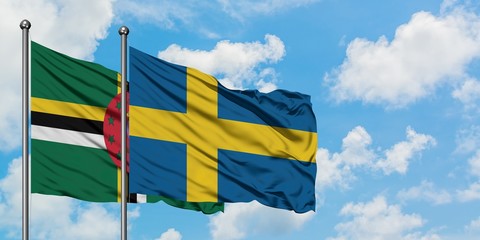 Dominica and Sweden flag waving in the wind against white cloudy blue sky together. Diplomacy concept, international relations.