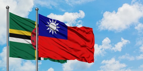 Dominica and Taiwan flag waving in the wind against white cloudy blue sky together. Diplomacy concept, international relations.
