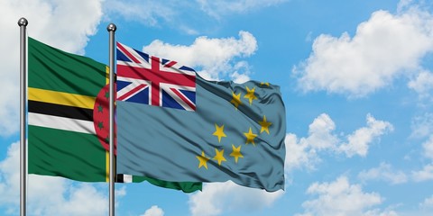 Dominica and Tuvalu flag waving in the wind against white cloudy blue sky together. Diplomacy concept, international relations.